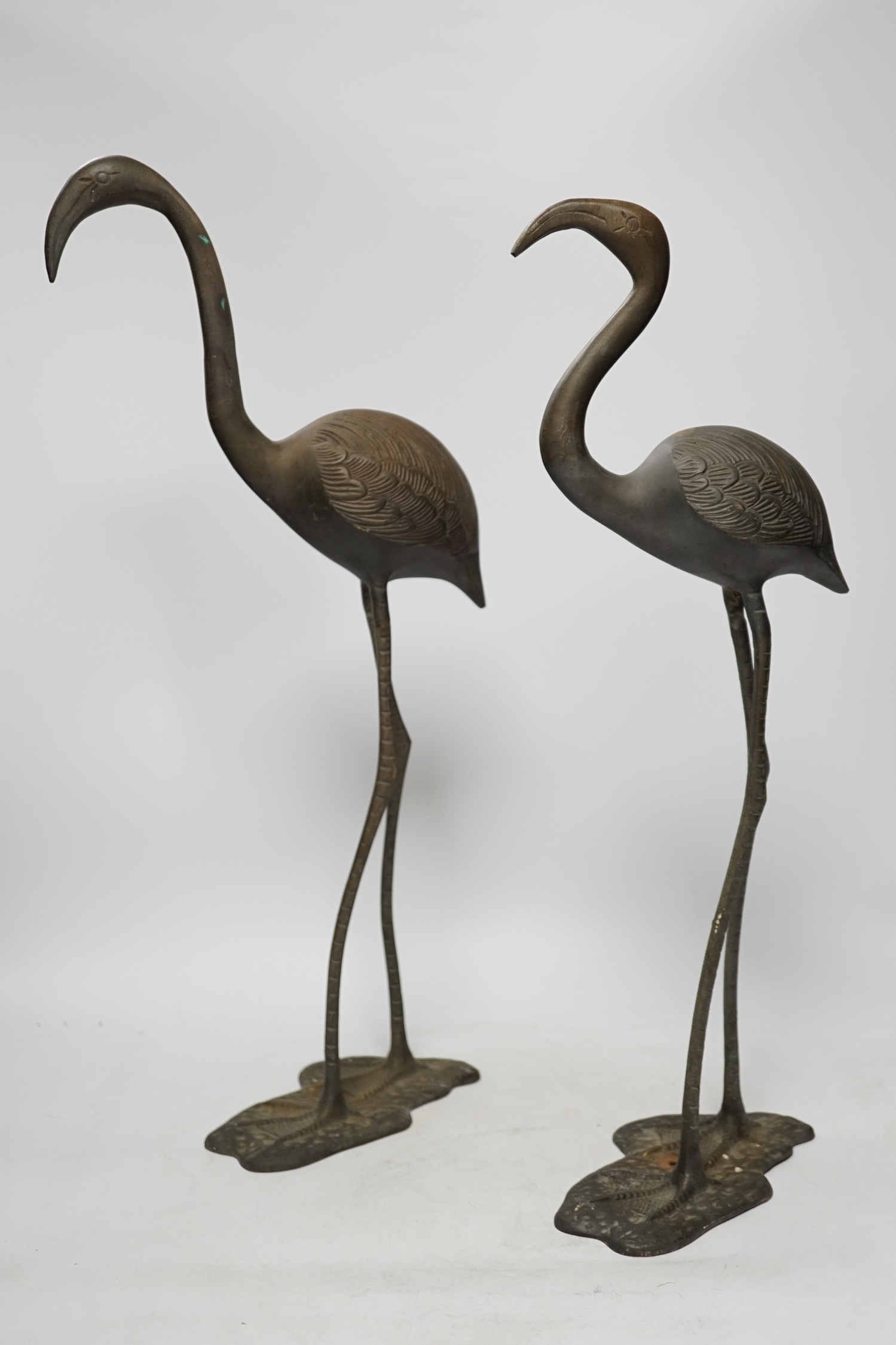 A pair of brass cranes, a pair of brass chamber sticks another chamberstick and a bowl, tallest 53cm high